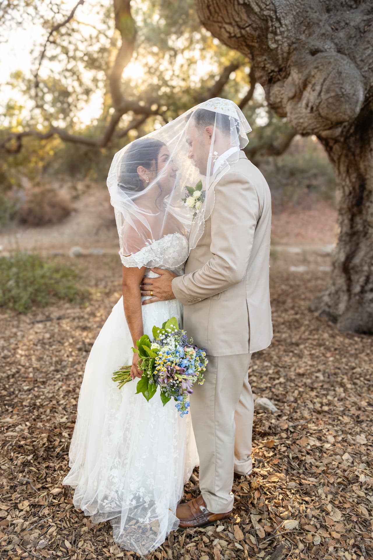 Bride and groom facing each other beneath her veil under oak trees, Ashley & Sean wedding