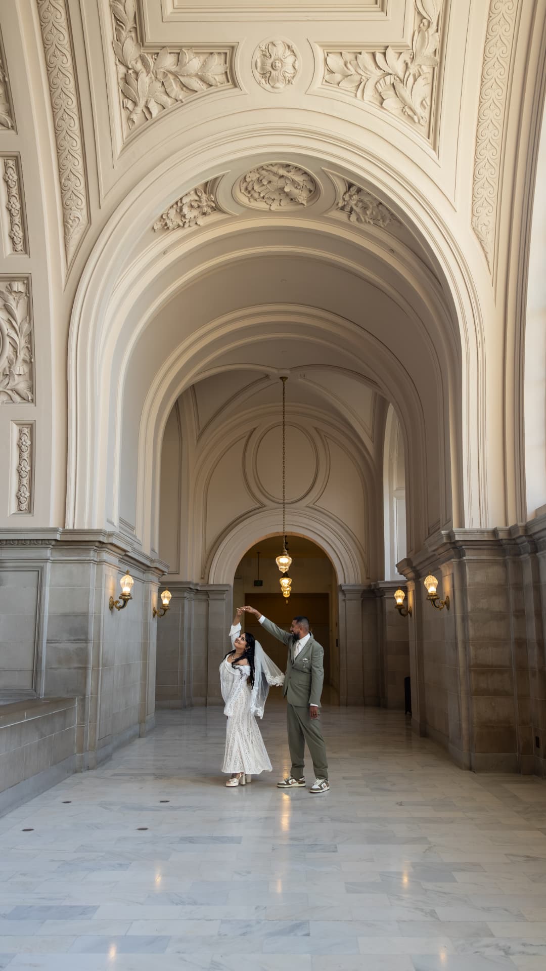 Bride and groom dancing together in the center of a grand marble hallway with soaring arched ceilings and classical stone architecture, Crystal & Joey wedding