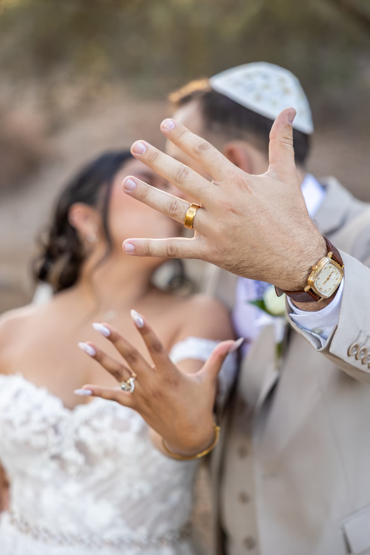 Bride and groom playfully showing their wedding rings to the camera